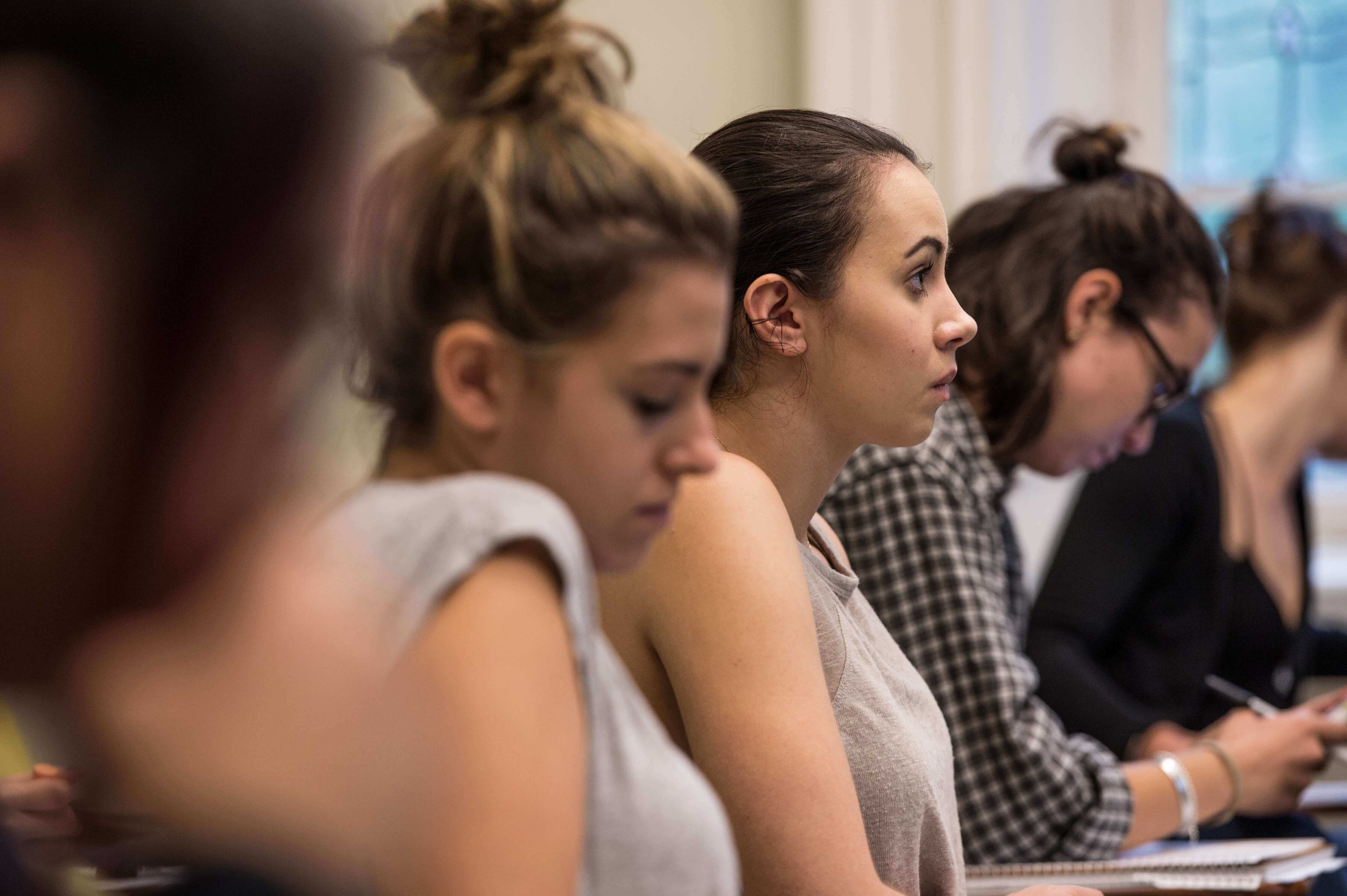 row of students in classroom, side angle