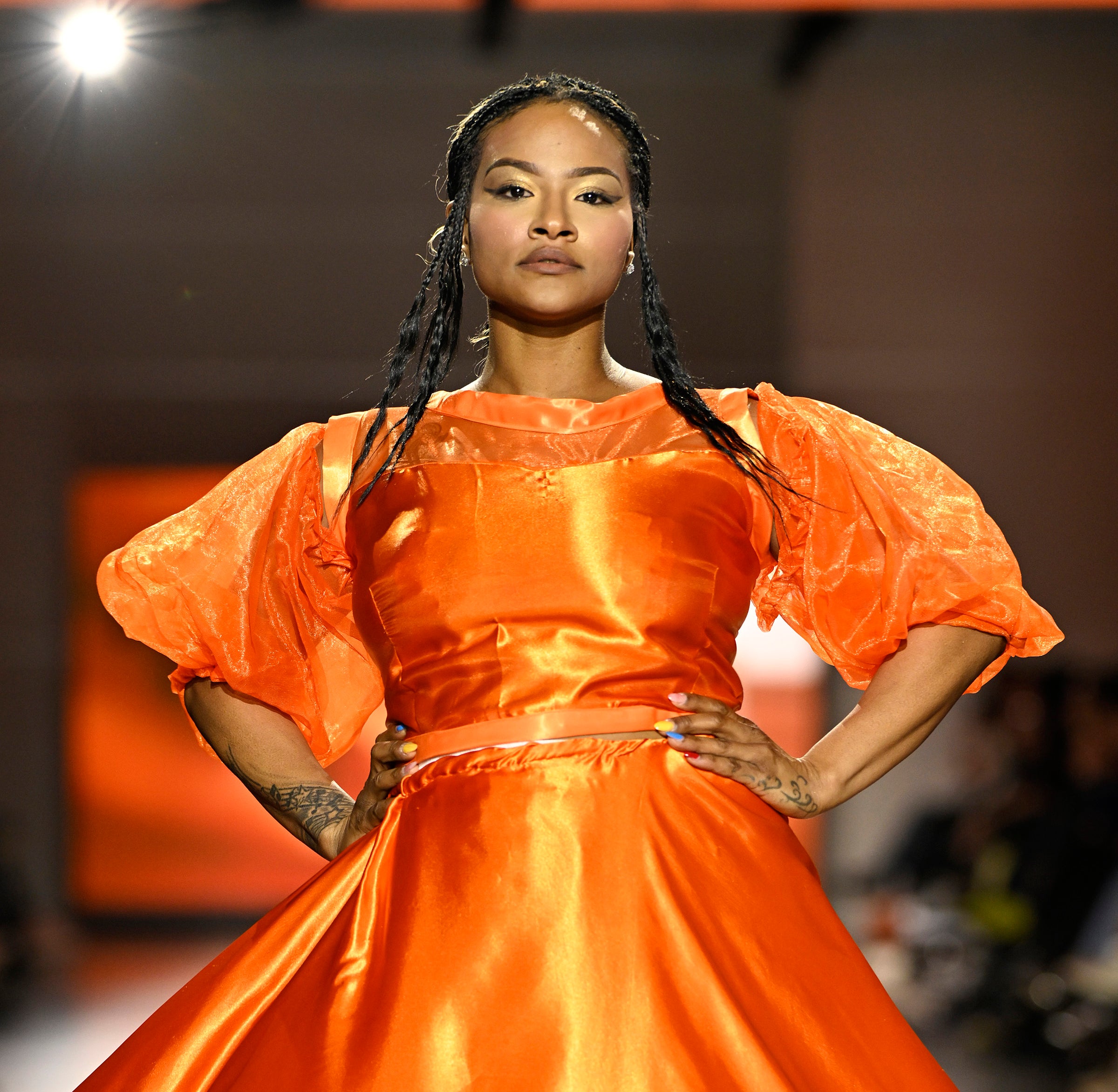 girl in an orange dress on a runway