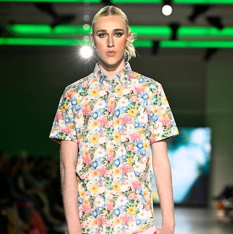 Model wearing a button-down shirt with a floral pattern. 