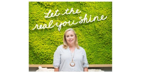 woman in white in front of green grass background